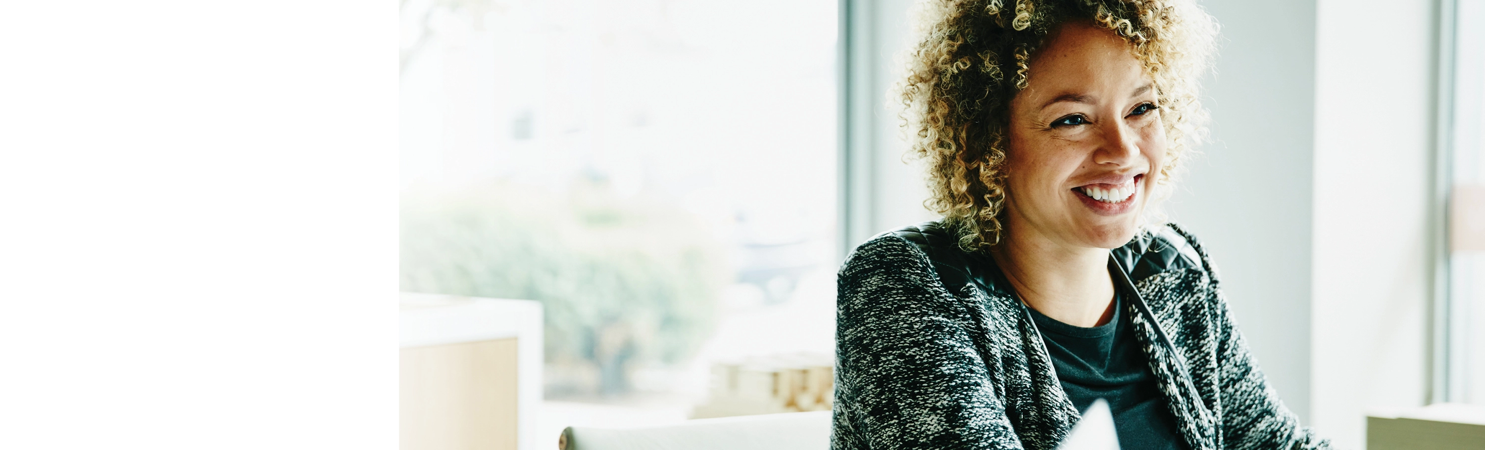 Black woman with curly afro smiling